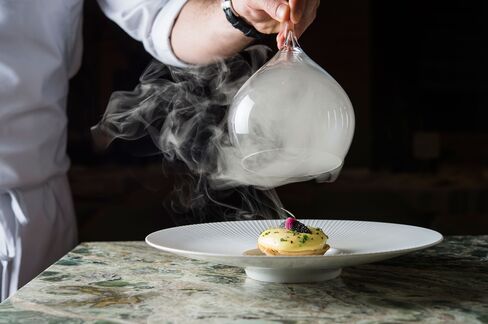 The sturgeon and sauerkraut tart at Gabriel Kreuther is presented in a cloud of smoke.