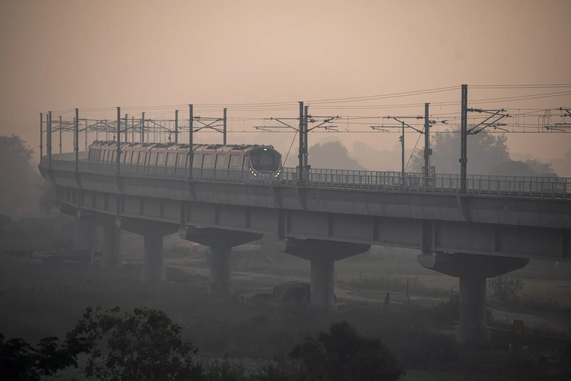 A Delhi Metro train travels along an elevated track shrouded in smog in New Delhi on Nov. 9.