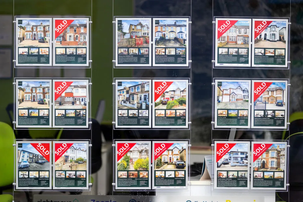 Properties for sale and sold in the window of an estate agents in London.