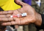 A community health worker shows a polio vaccine dose during an&nbsp;immunization campaign in Kiamako, Nairobi on July 19, 2021.