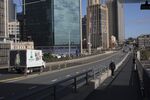 A pedestrian walks next to a highway in Sydney, Australia.