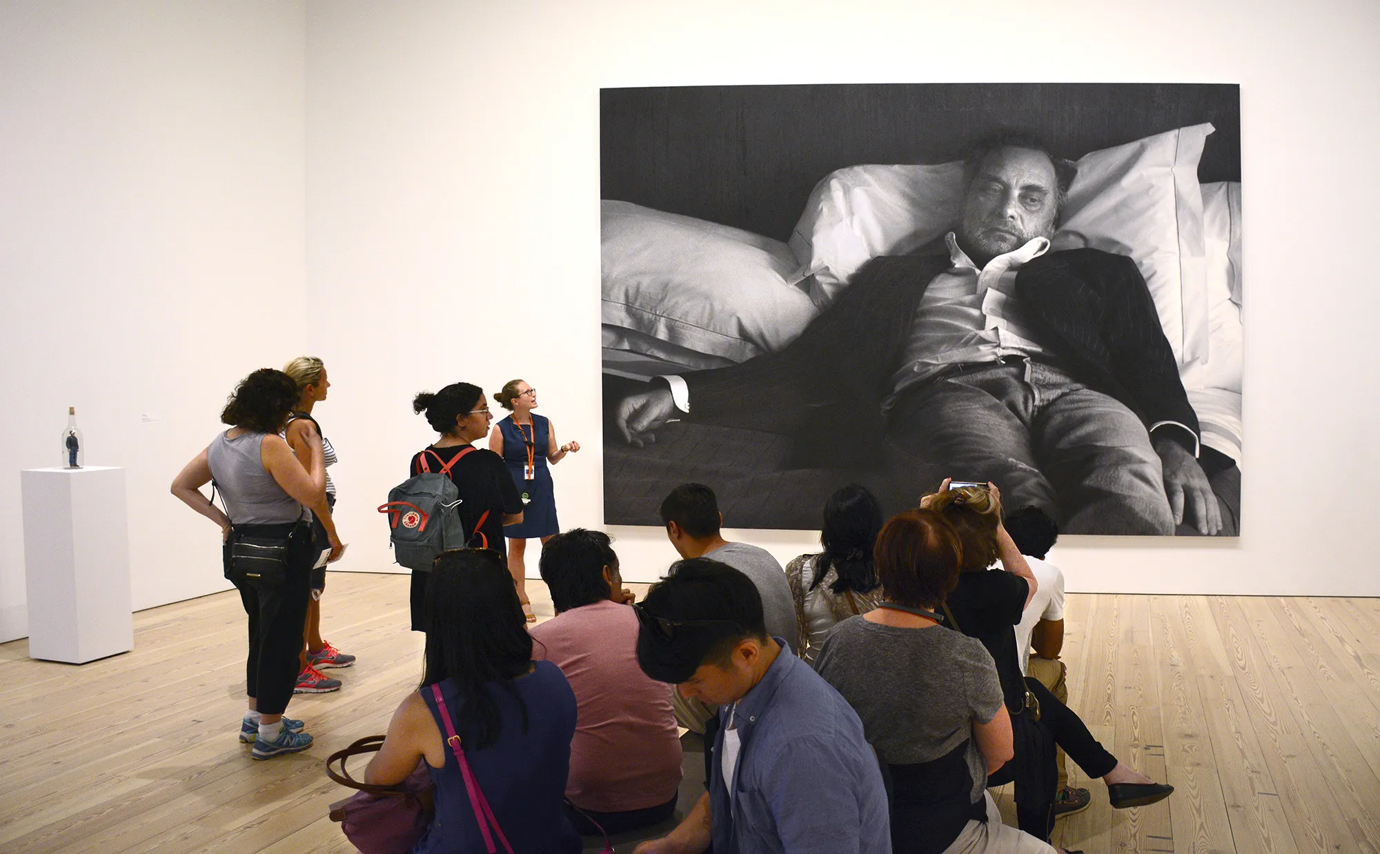 Whitney Museum of Art visitors listen as a museum guide discusses artist Rudolf Stingel’s 2005 painting, ‘Untitled (After Sam)’