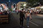 Pedestrians walk along Fifth Avenue, closed to vehicles for outdoor dining, in the Gaslamp District of downtown San Diego. Some cities are considering making these Covid-era traffic restrictions permanent.&nbsp;