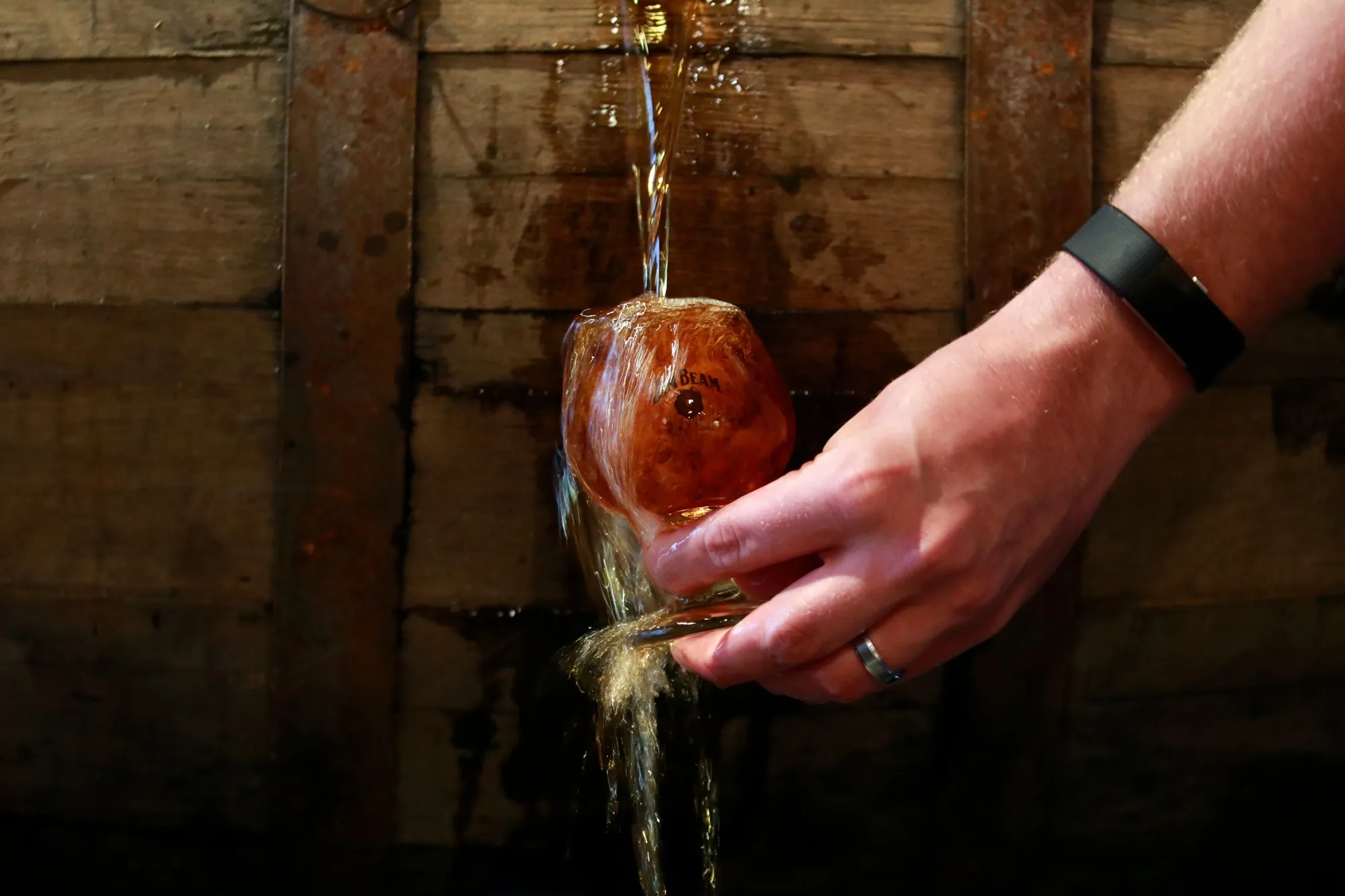A tour guide pours bourbon whiskey from a barrel at the James B. Beam distillery in Clermont, Kentucky, US.
