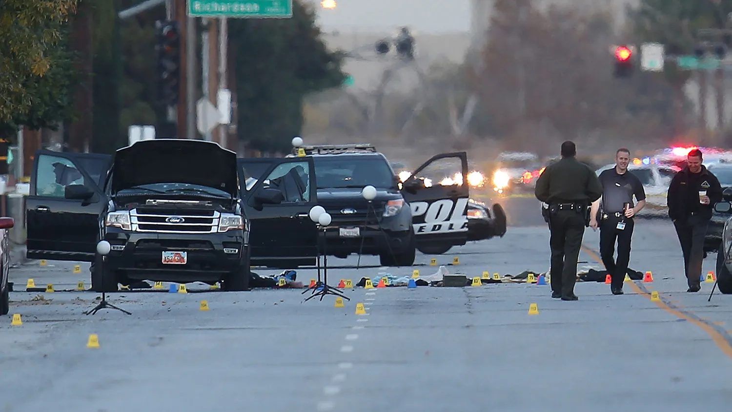 Law enforcement officials continue their investigation around the Ford SUV vehicle that was the scene where suspects of the shooting at the Inland Regional Center were killed on Dec. 4, 2015, in San Bernardino, California.
