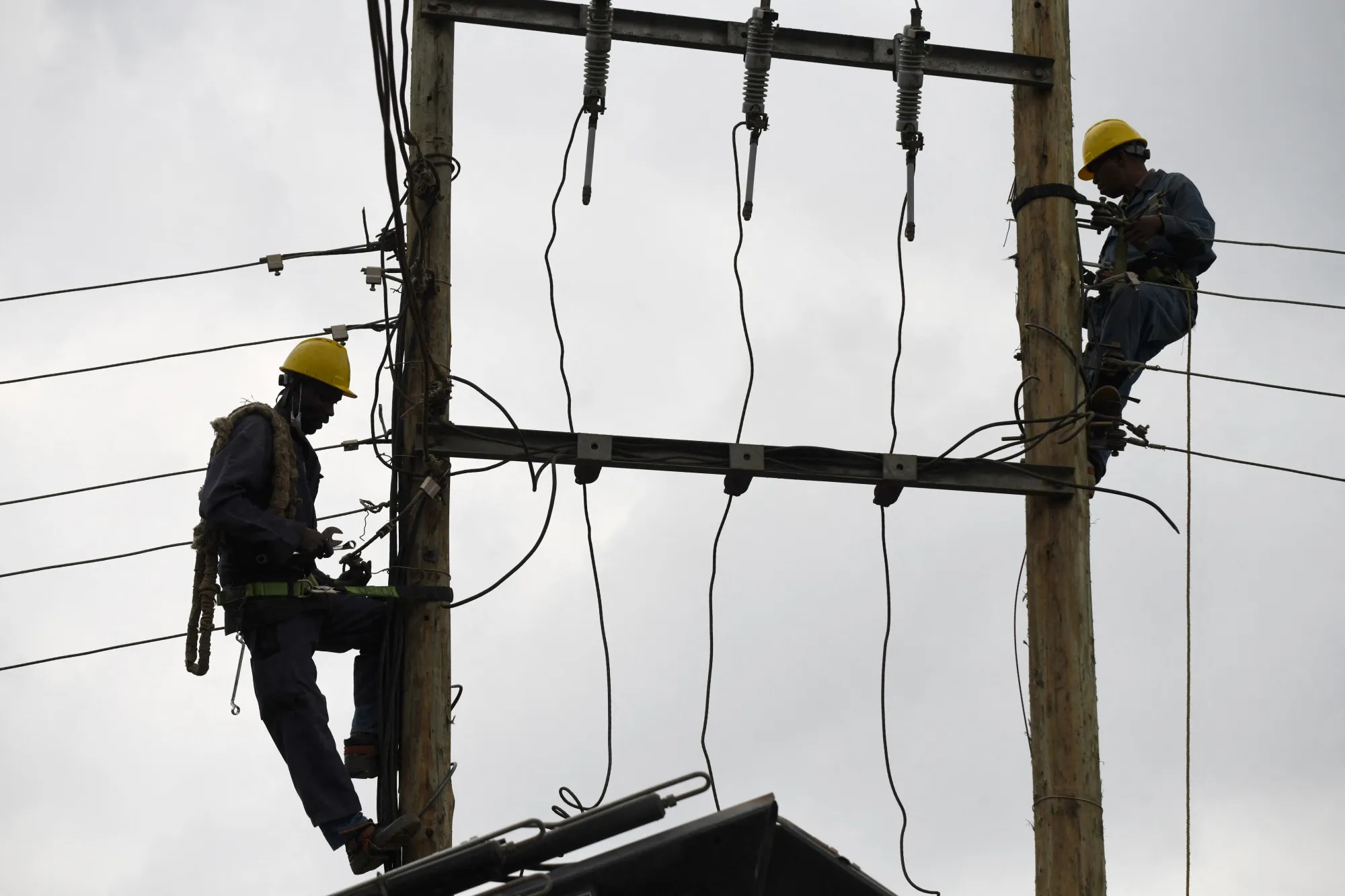 Kenya Power and Lighting Company employees working on cables in Nairobi.&nbsp;