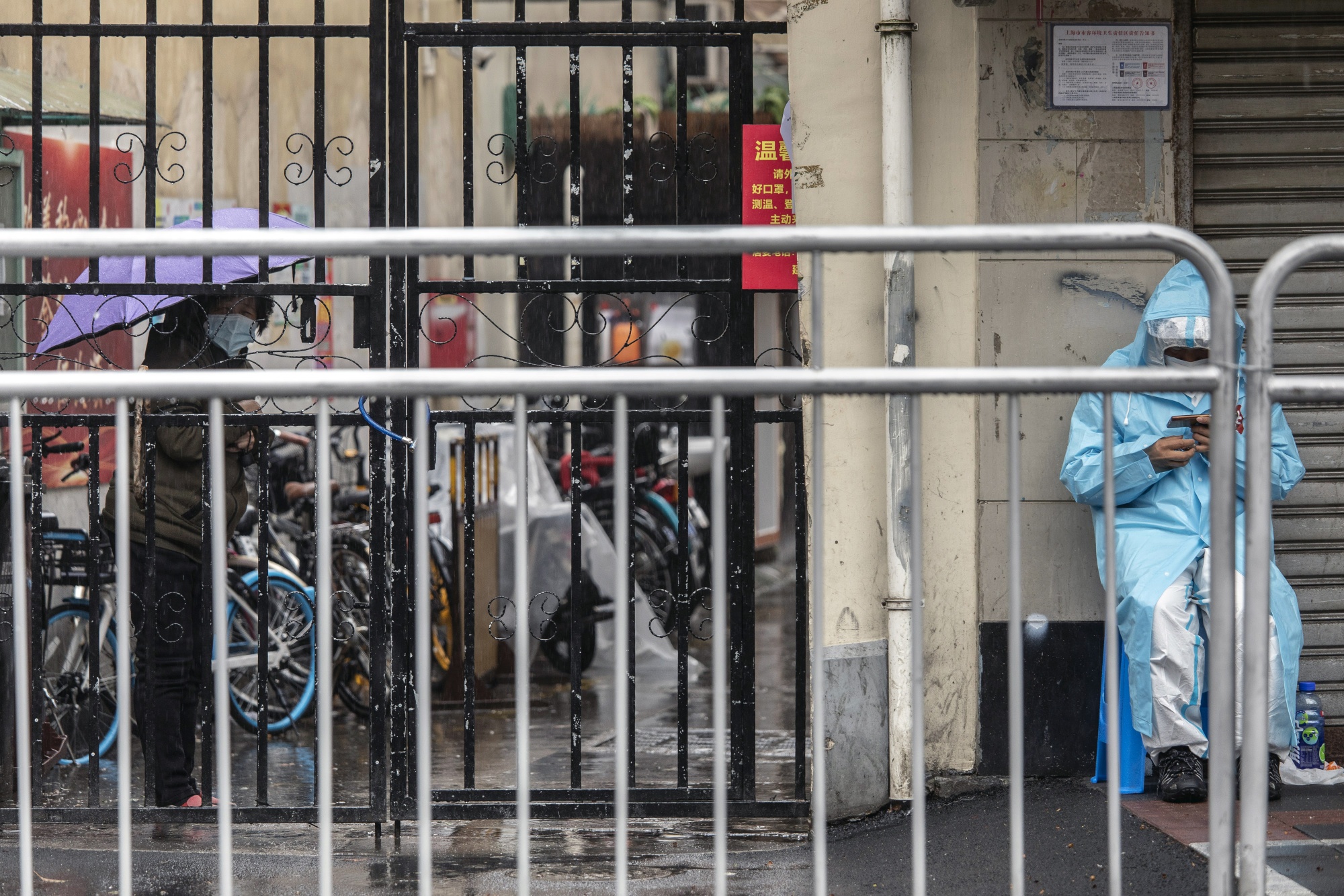A worker&nbsp;at a neighborhood placed under lockdown due to Covid-19 in Shanghai, on March 25.