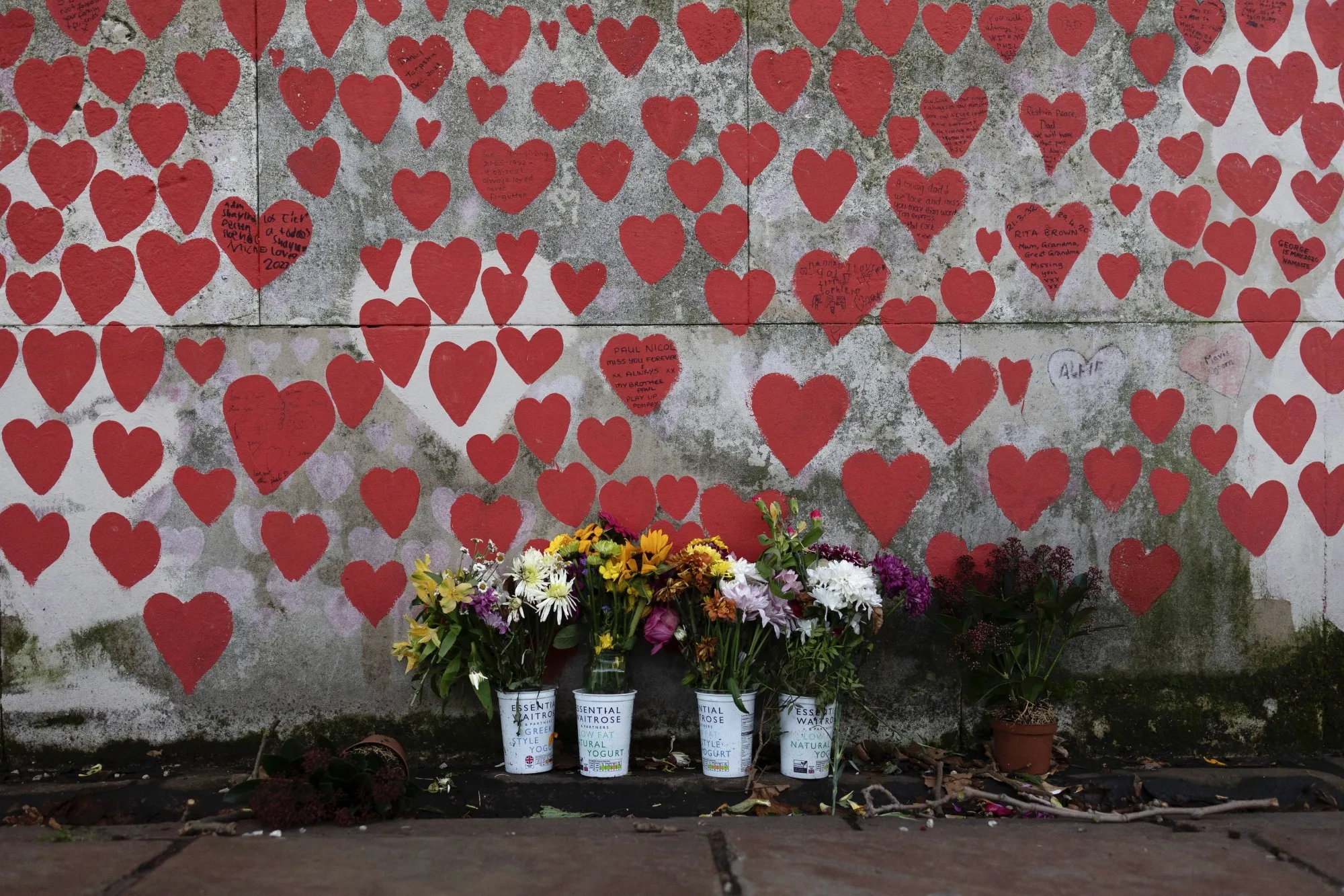 Flowers next to the UK’s Covid memorial wall in London pay tribute to people who&nbsp;died of the illness.&nbsp;