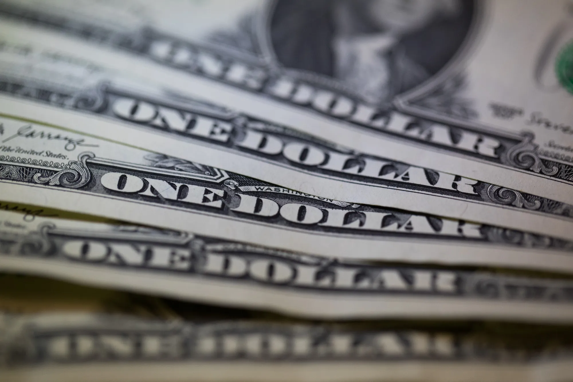 A collection of U.S. one dollar bills are displayed in this arranged photograph.