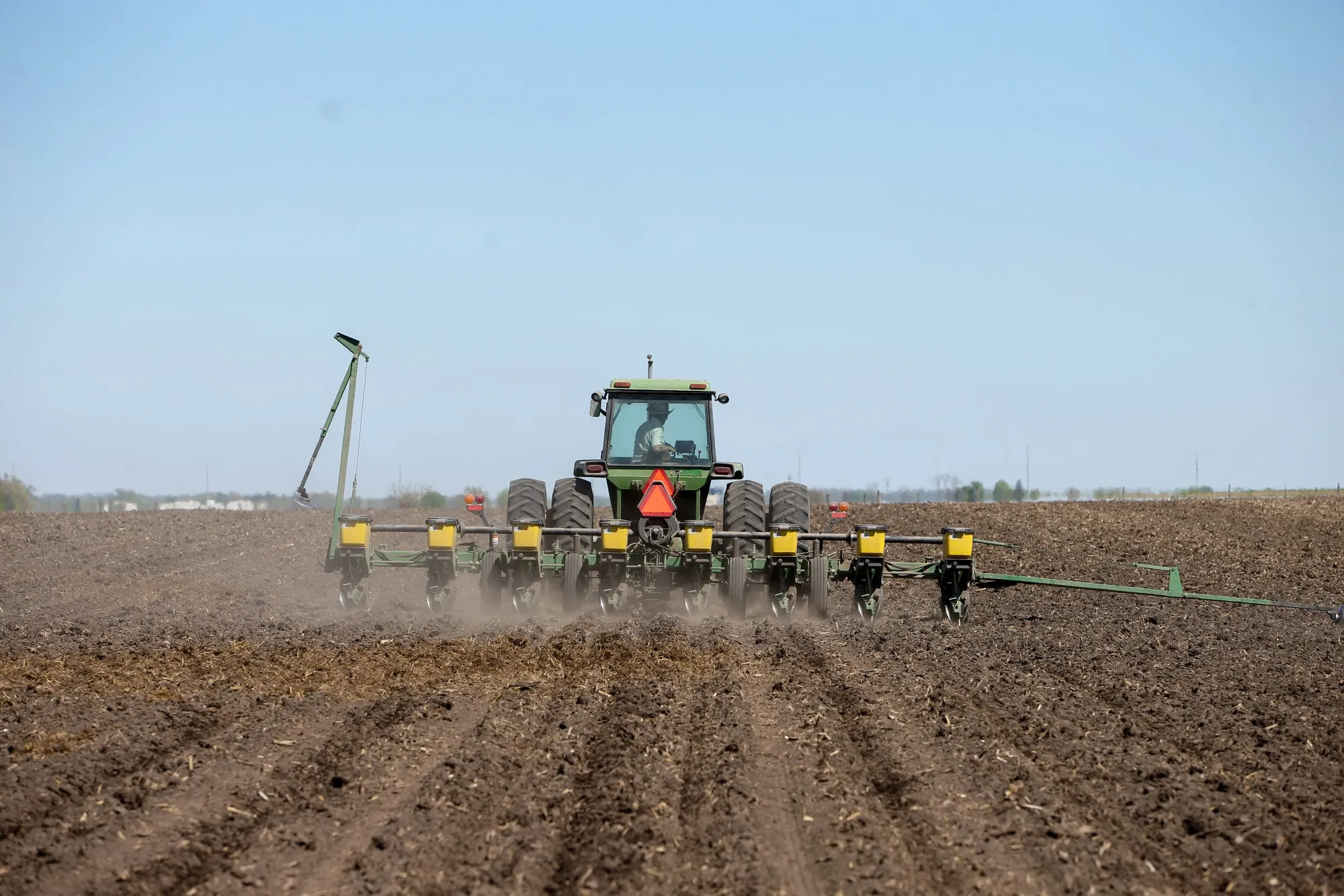 A worker uses a tractor to plant soybeans at a farm in Tiffin, Iowa, in May.