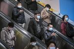 Passengers wearing protective masks ride an escalator at a subway station in Shanghai.