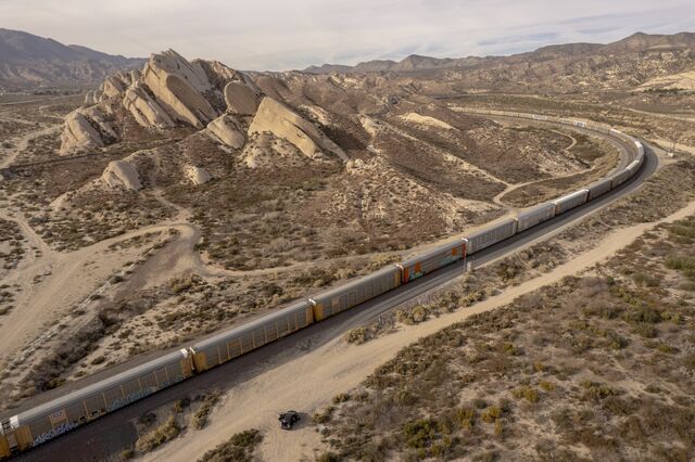 A freight train carrying shipping containers travels through Cajon Pass in Phelan, California, U.S., on Friday, Nov. 19, 2021. The most recent government report on producer prices showed freight transportation by rail is costing shippers more, with a 7.3% increase in October from the same month last year.