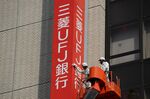 A worker wipe new signage for MUFG Bank Ltd.