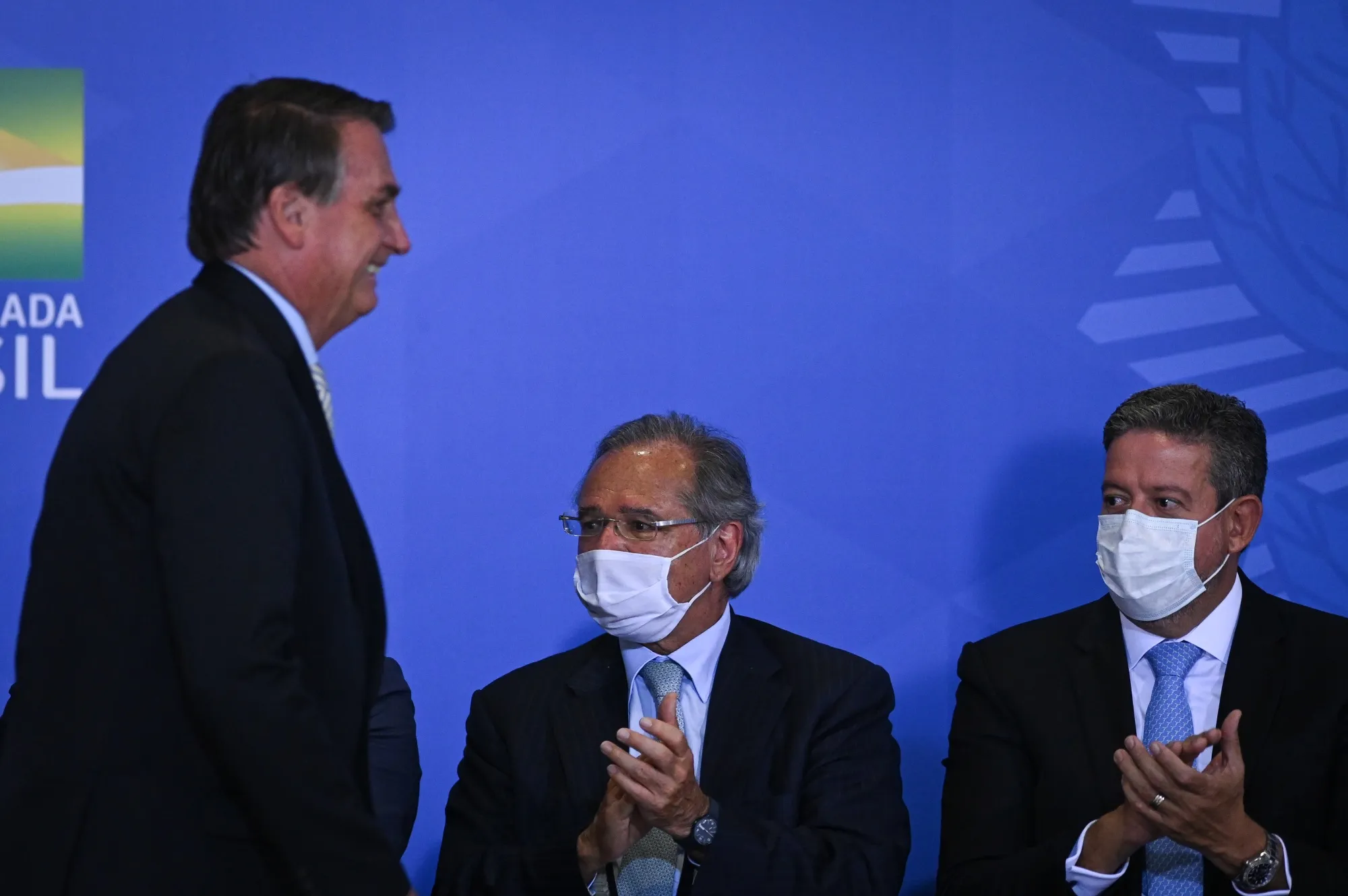 President Jair Bolsonarowalks past Economy Minister Paulo Guedes (center) and Lower House Speaker Arthur Lira