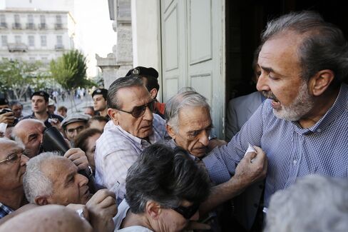 Pensioners with tickets enter a National Bank of Greece SA bank to collect their pensions in Greece, on July 1, 2015. Photographer: Simon Dawson/Bloomberg