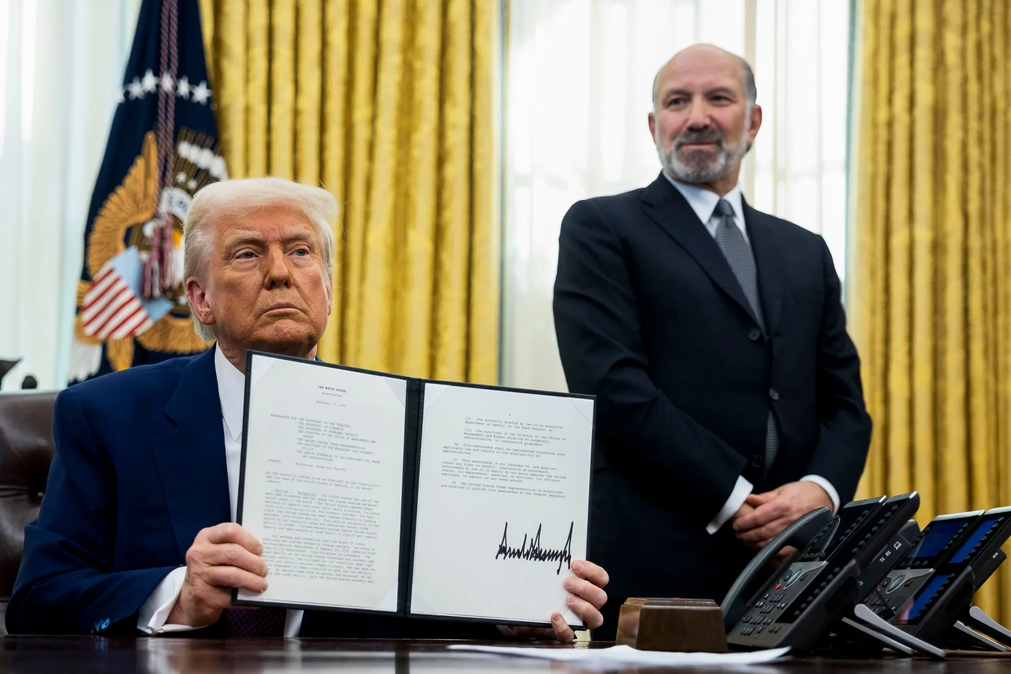 Howard Lutnick, chief executive officer of Cantor Fitzgerald LP and US commerce secretary nominee for US President Donald Trump, right, watches as President Donald Trump displays a signed executive order in the Oval Office of the White House in Washington, DC, US, on Thursday, Feb. 13, 2025.&nbsp;