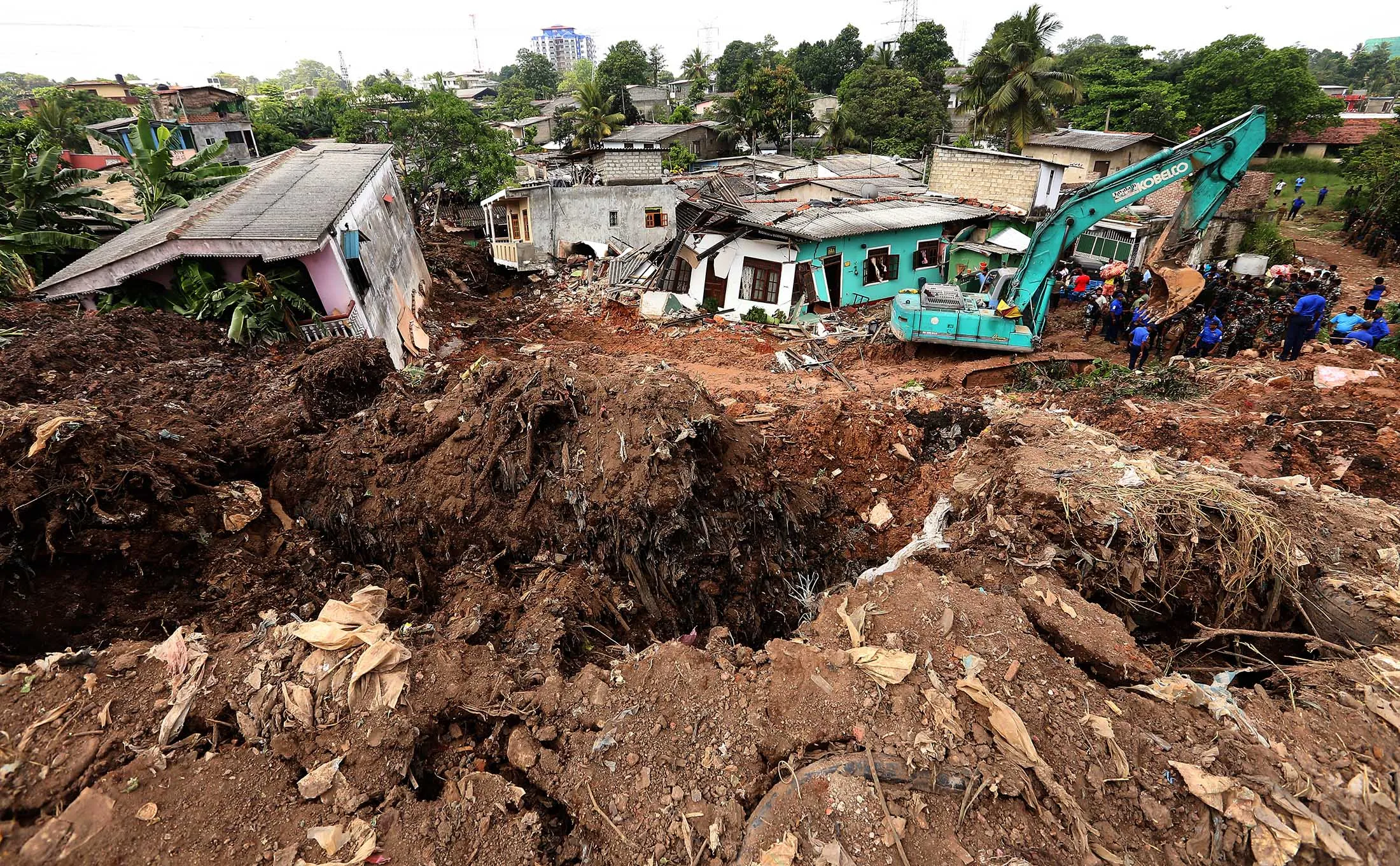 Heavy machinery are used by Sri Lanka Army personnel during rescue operations at the collapsed garbage mountain in Meethotamulla, Colombo, Sri Lanka 15 April 2017. Following a fire that broke out on Friday 14 2017 at the garbage dump that had grown into a huge man-made mountain measuring 300 feet (91.5 metres) in height, resulting in a large section collapsing on to the houses of low and middle income earners' dwellings in the vicinity. According to local officials, 40 houses have been buried with 10 deaths reported and another seven undergoing treatment at the National Hospital in Colombo. Authorities are working on cause of the fire, while search efforts for those possibly still trapped or buried under the debris continue
