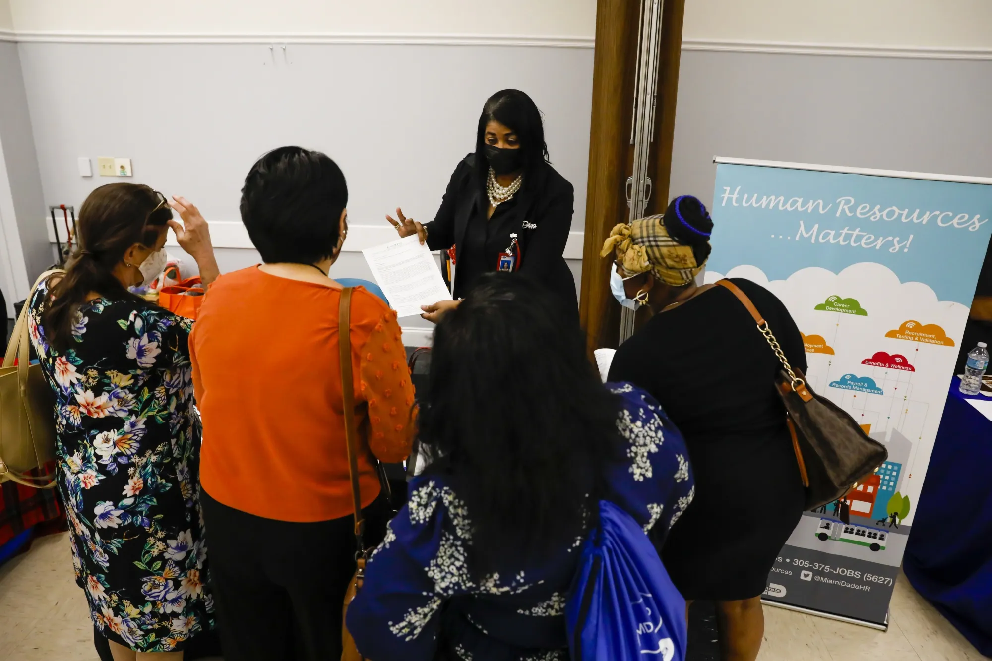 A recruiter speaks with job seekers during a Miami-Dade County job fair in Miami, Florida.