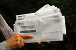 An Oakland resident displays mail that was received at her home address for other people who presumably attempted to defraud the California Employment Development Department.