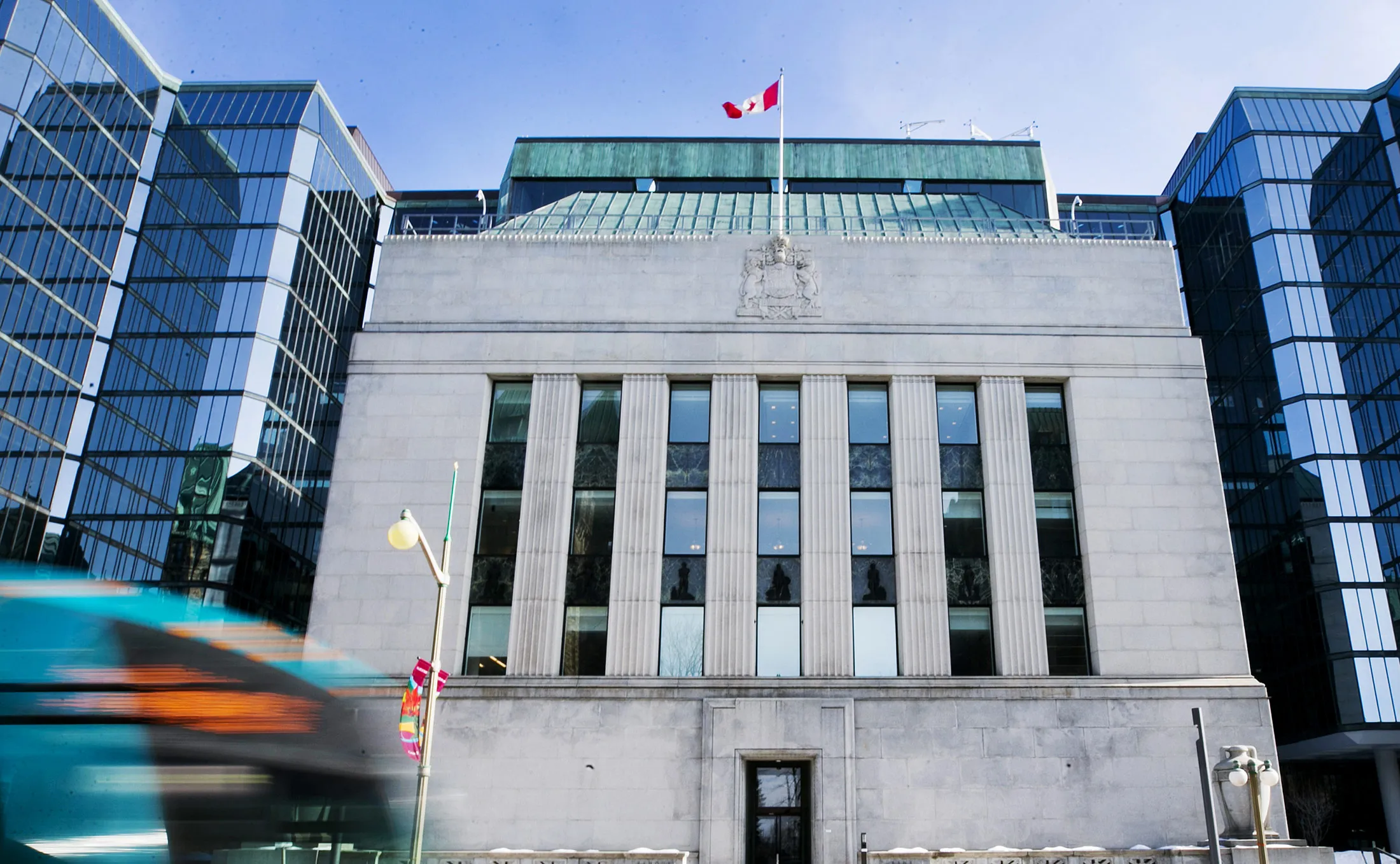 Vehicles drive past the Bank of Canada offices in Ottawa, Ontario, Canada, on Monday, March 20, 2017. Trudeau's finance chief, Bill Morneau, will release his second federal budget Wednesday and all signs point to more red ink: annual deficits are presently projected in the C$30 billion (C$22 billion) range -- the highest since the aftermath of the 2008 downturn -- with no forecast return to balance.
