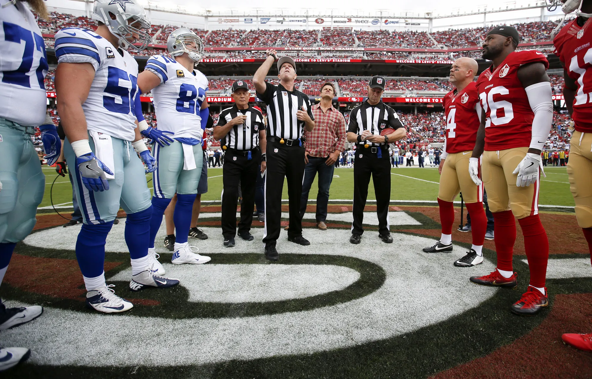 Captains of the San Francisco 49ers and the Dallas Cowboys stand at midfield for the coin flip prior to a game in Santa Clara, California, on Oct. 2, 2016
