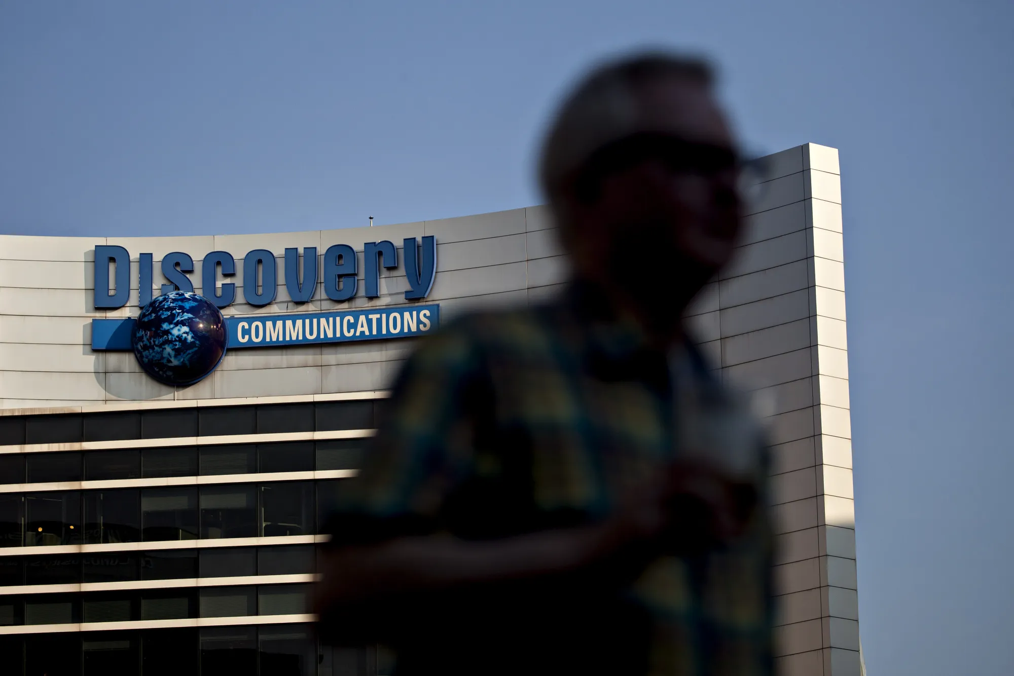 A pedestrian passes in front of Discovery Communications headquarters in Silver Spring, Maryland.