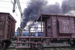 A railway employee stands on frieght train as smoke comes out from fire at the rail yard at Mughalsarai Rail Junction in Mughalsarai, India.
