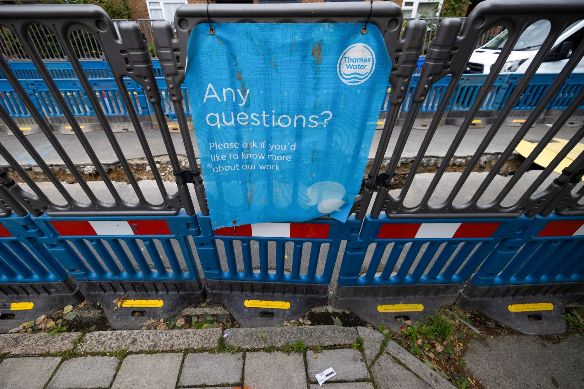 A public information sign from Thames Water Ltd. on barriers surrounding water supply works in London.