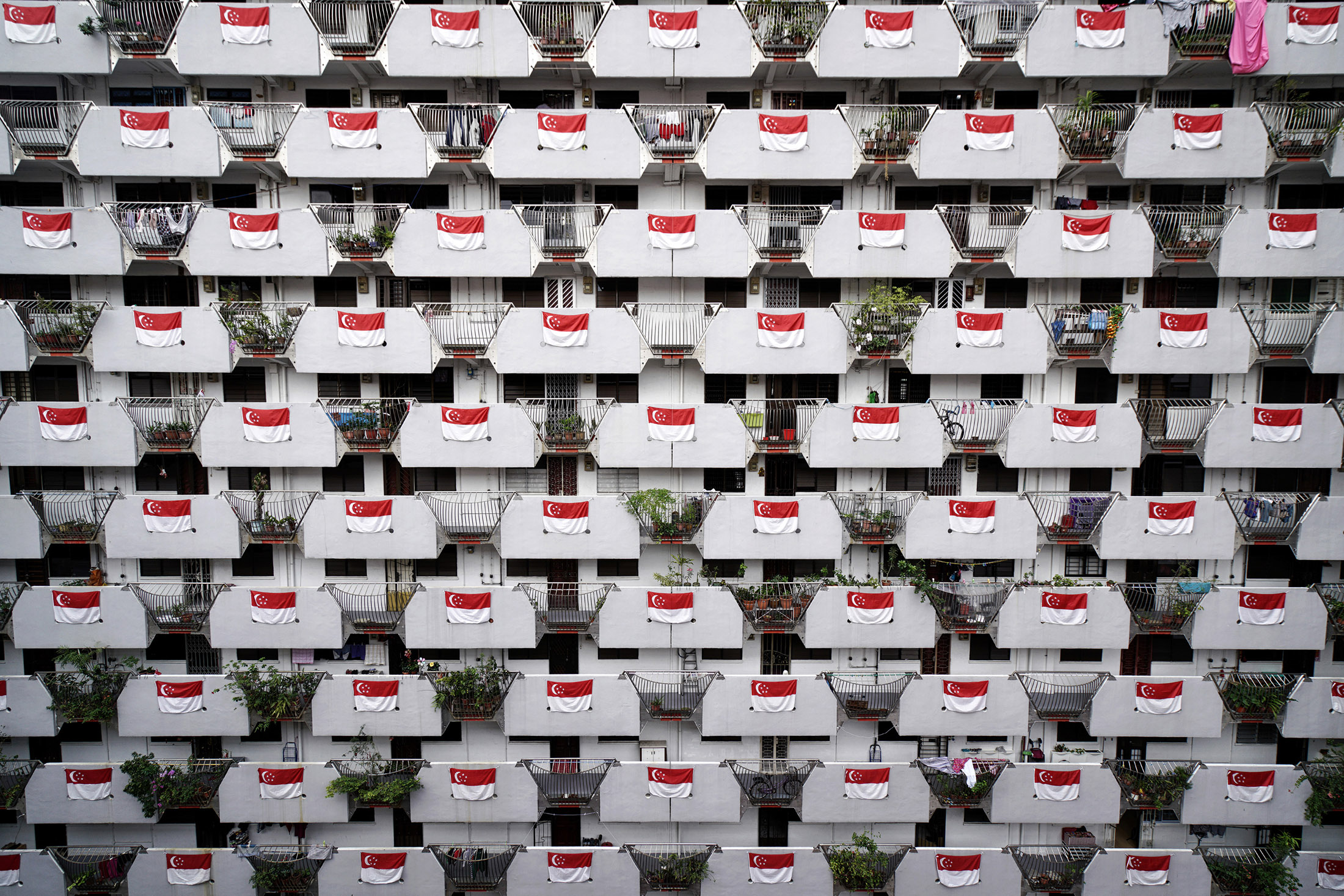 Singapore national flags are displayed on a residential apartment block in Singapore.

