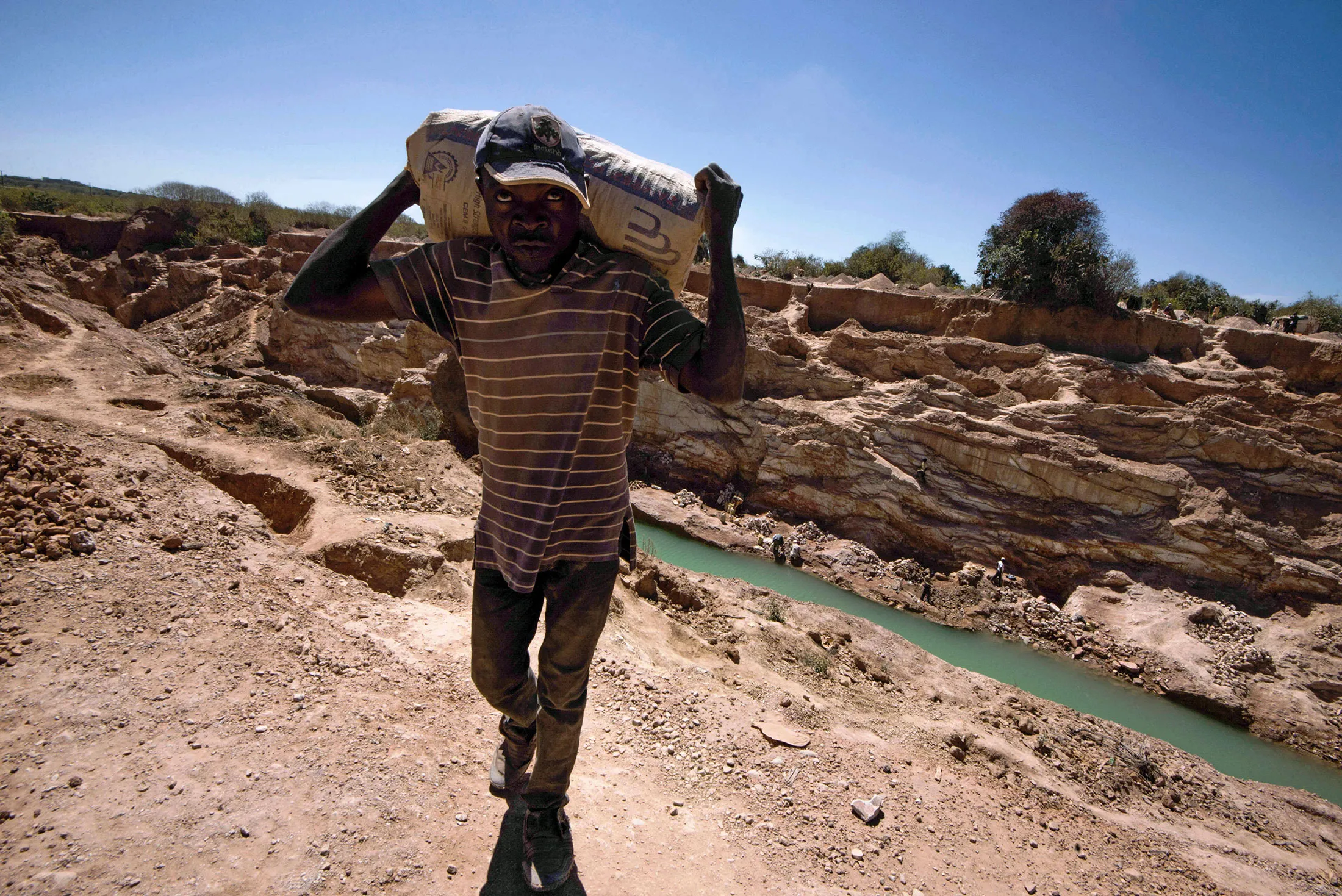A man carries a bag of copper at a mine quarry and cobalt pit in Lubumbashi.