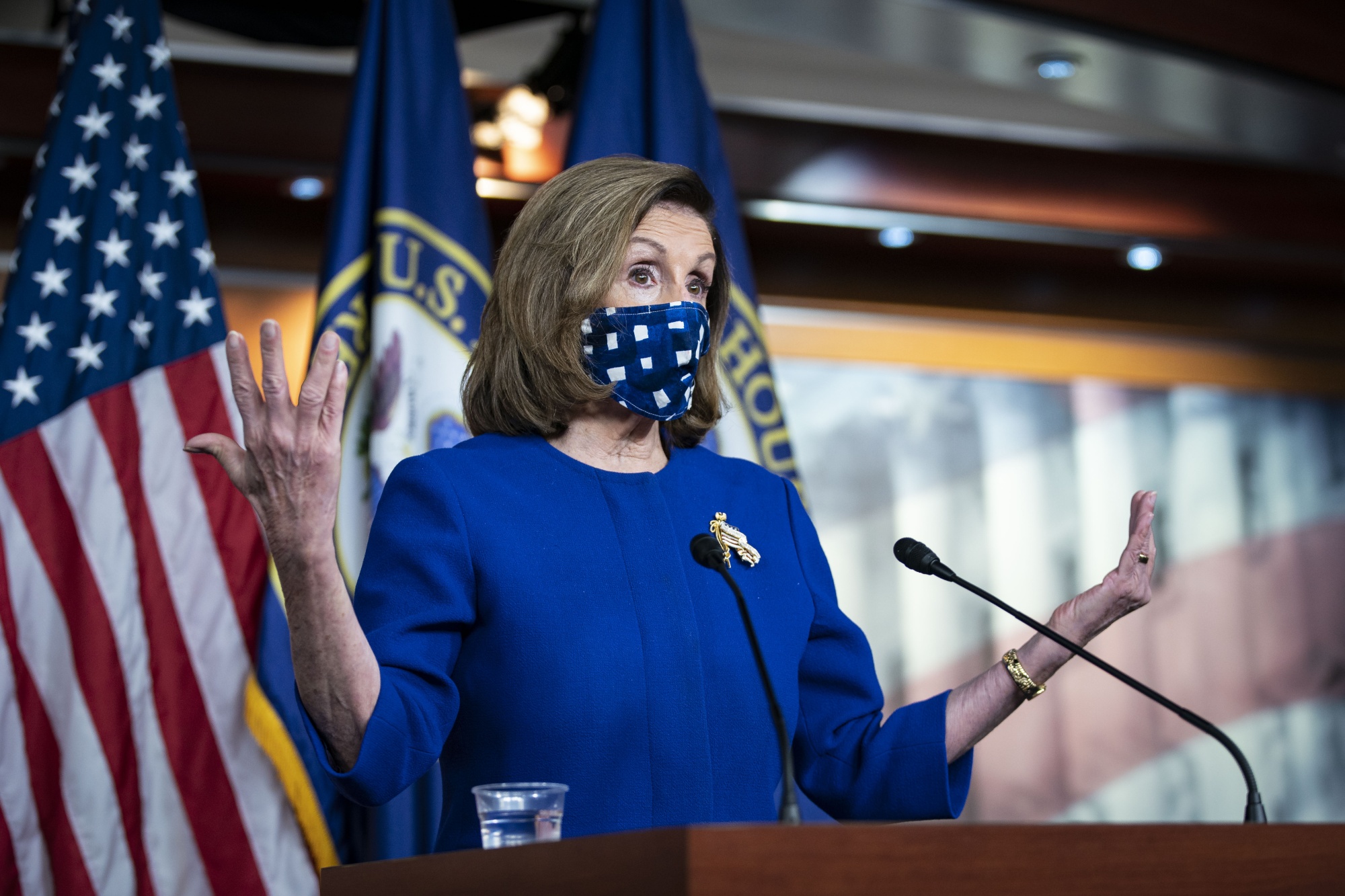 speaker pelosi in a mask at a podium