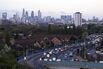 Traffic travels along the A13 dual carriageway as the City of London financial district stands on the skyline beyond in London, U.K., on Monday, April 10, 2017.