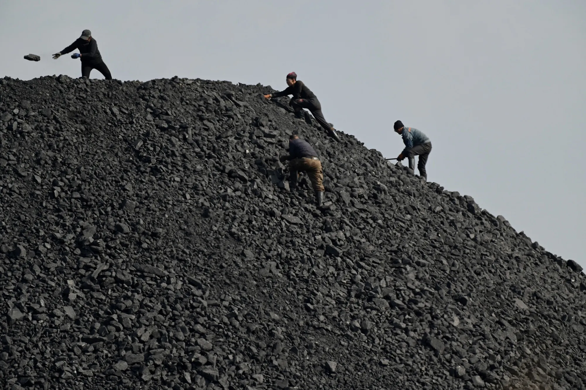 Workers sort rocks near a coal mine in Datong, China.