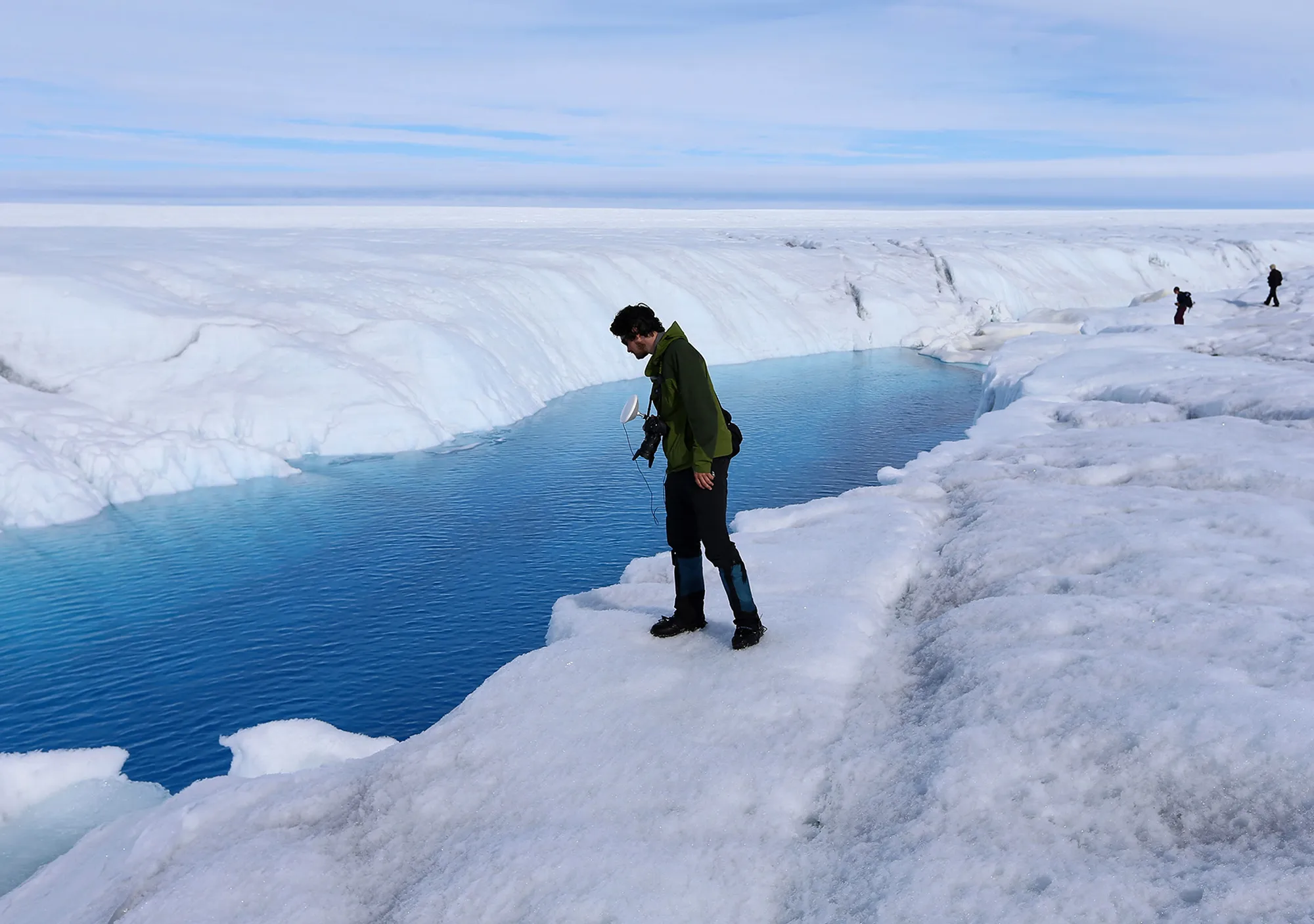 A student looks at a meltwater stream on the Glacial Ice Sheet, Greenland.