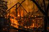 Flames engulf a home as it burns along Highway 128 during the Kincade fire in Healdsburg, California, U.S., on Sunday, Oct. 27, 2019. The wildfire that erupted in California's wine country minutes after a PG&E Corp. power line went down has prompted an expanded evacuation order, as officials warn high winds could drive the blaze toward one of the region's largest towns.