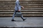 A pedestrian walks along Wall Street near the New York Stock Exchange (NYSE) in New York, U.S., on Wednesday, Sept. 6, 2017. Markets stabilized Wednesday, even as North Korean tensions continued to simmer, another hurricane tore through the Caribbean and a key member of the Fed resigned.