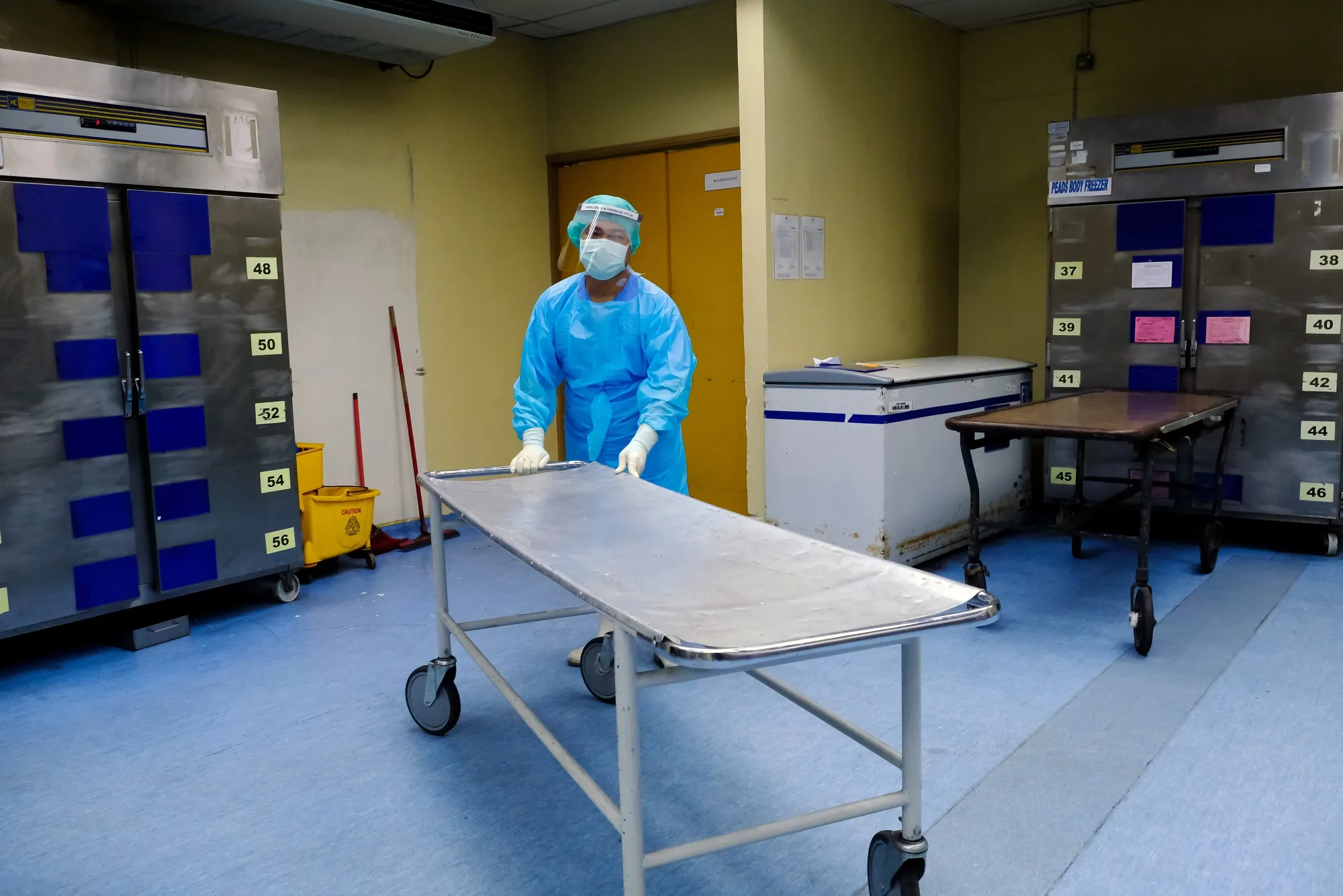 A health worker in the Covid-19 morgue at a hospital in Kuala Lumpur, Malaysia, in 2021. The pandemic virus continues to be a bigger killer than the flu, even amid hopes it will one day fade into the background with other respiratory diseases.