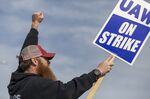 A Deere & Co. worker holds a sign during a strike outside the John Deere Des Moines Works facility in Ankeny, Iowa on Oct. 15. 