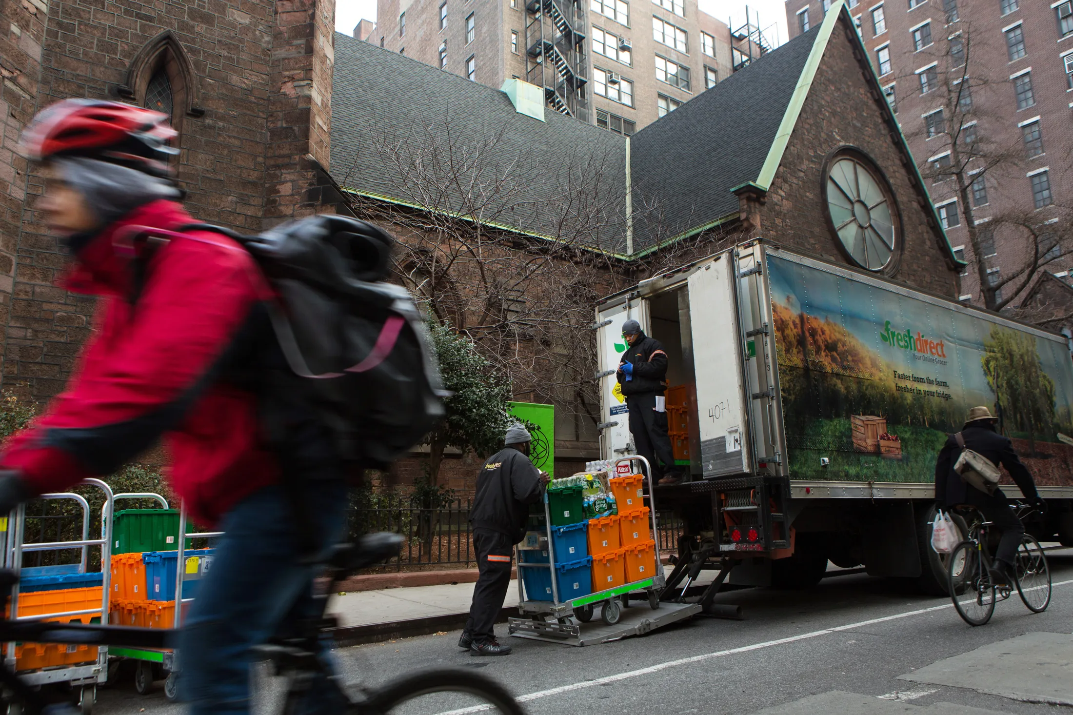 Workers unload crates of groceries during a FreshDirect delivery in New York.
