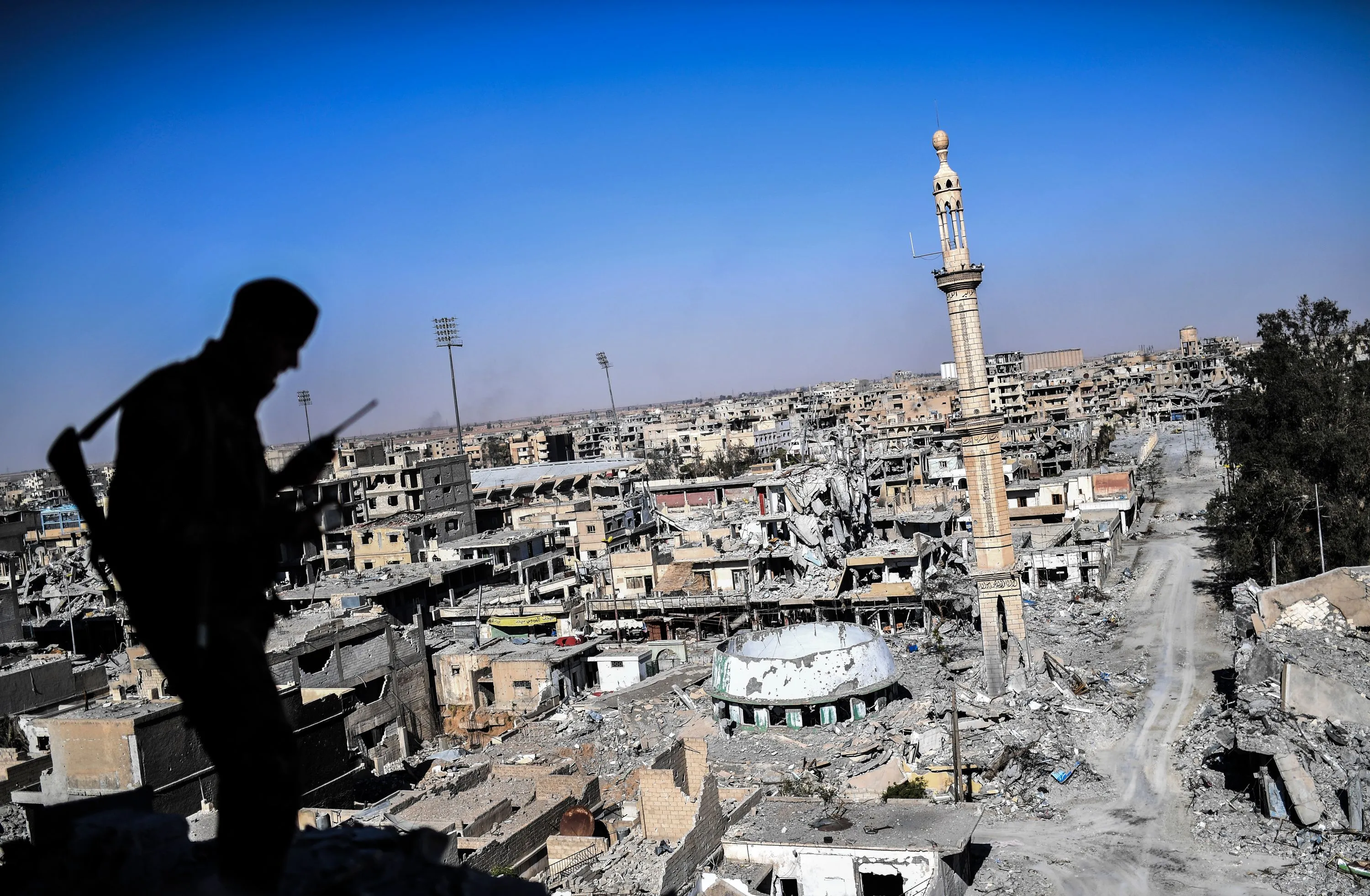 A member of the Syrian Democratic Forces (SDF), backed by US special forces, talks on the radio near Raqa's stadium as they clear the last positions on the frontline on October 16, 2017 in the Islamic State (IS) group jihadists crumbling stronghold.