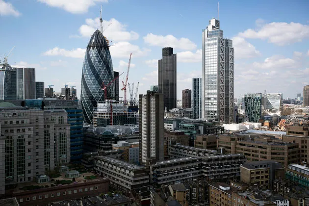Residential and commercial properties stand in front of the Swiss Re building in London