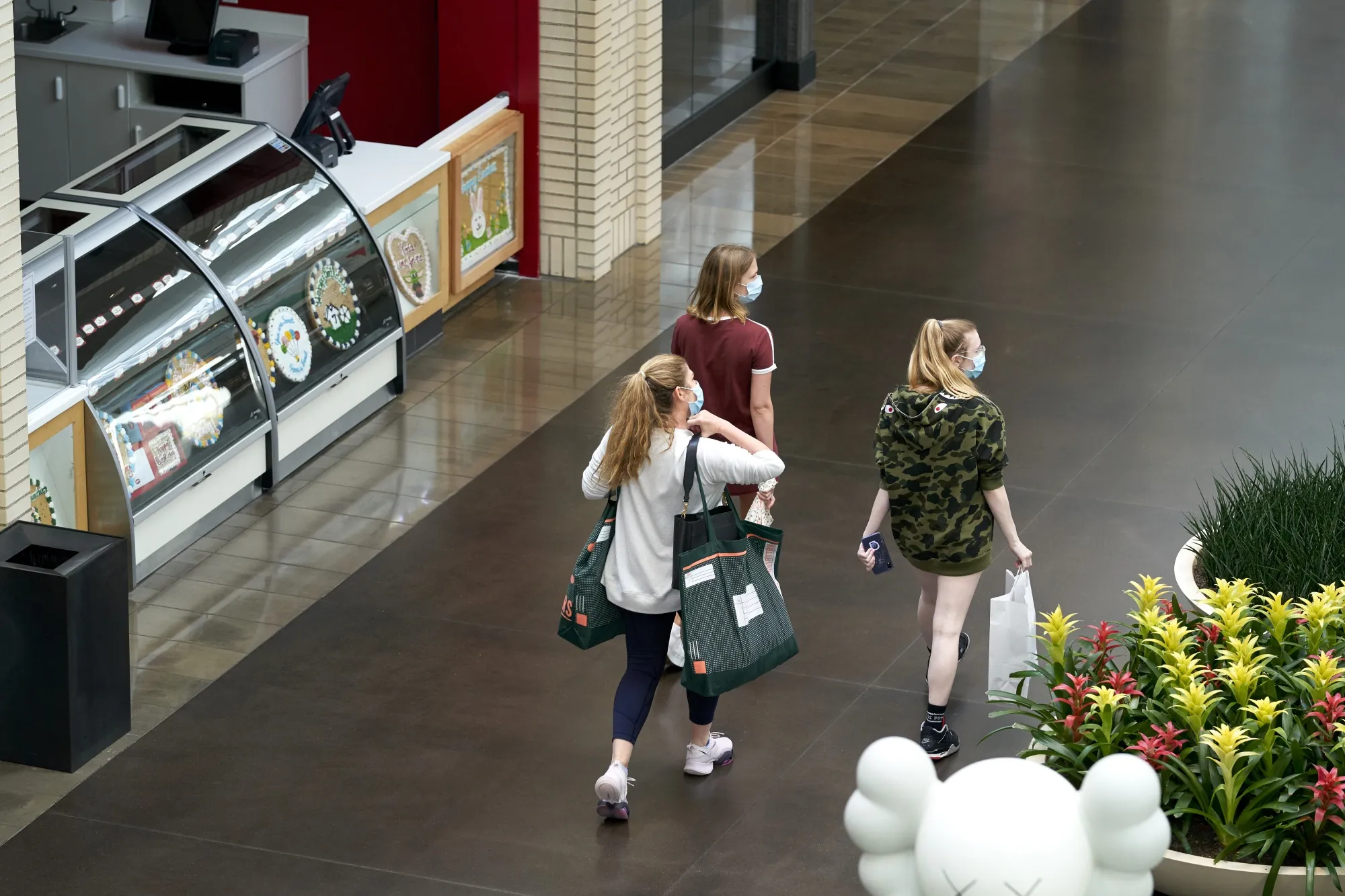 Shoppers wearing protective masks walk through NorthPark Center mall in Dallas, Texas, U.S., onMay 1.