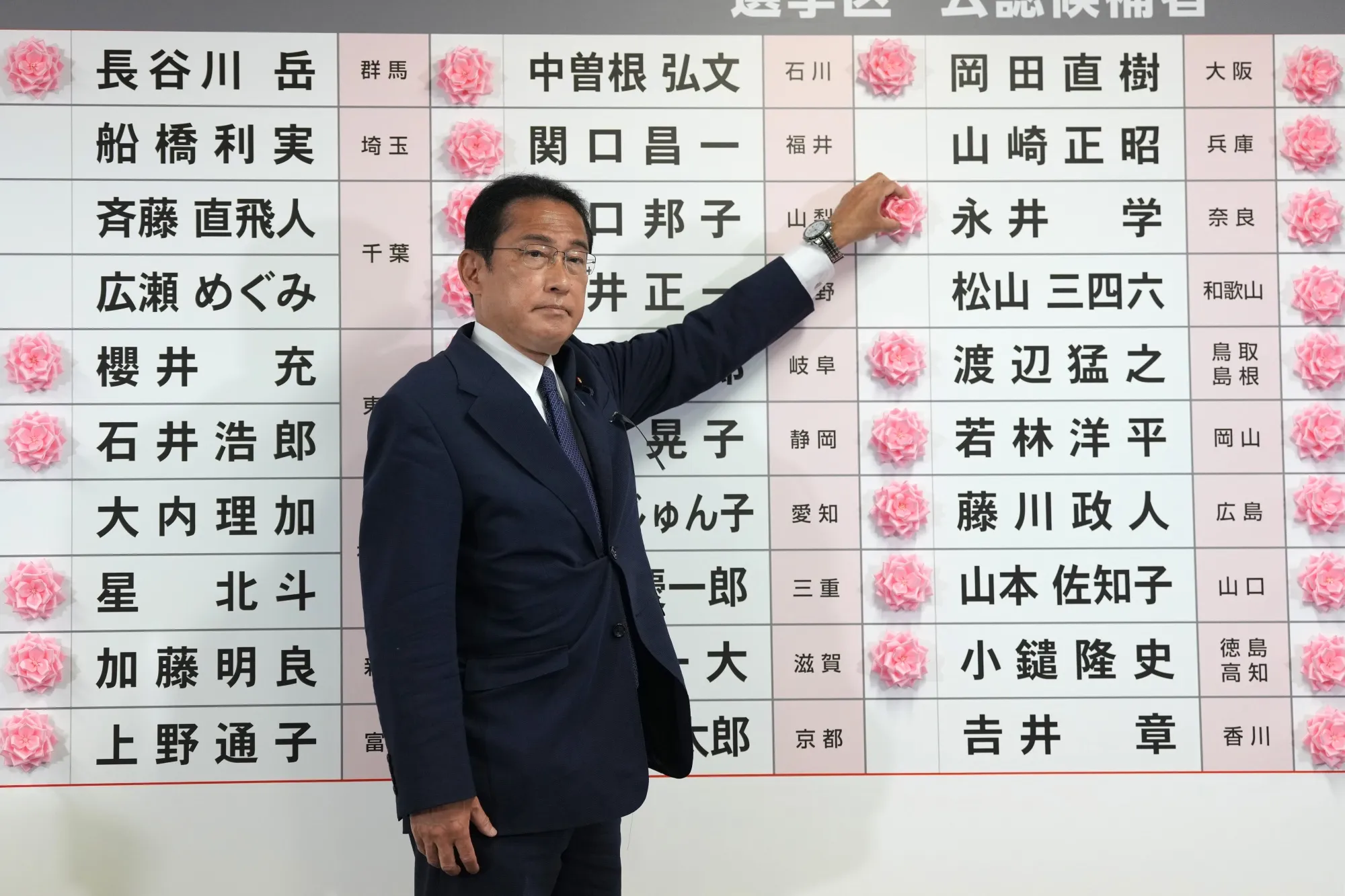 Fumio Kishida places a paper rose on an LDP candidate’s name, to indicate a victory in the upper house election, on July 10.