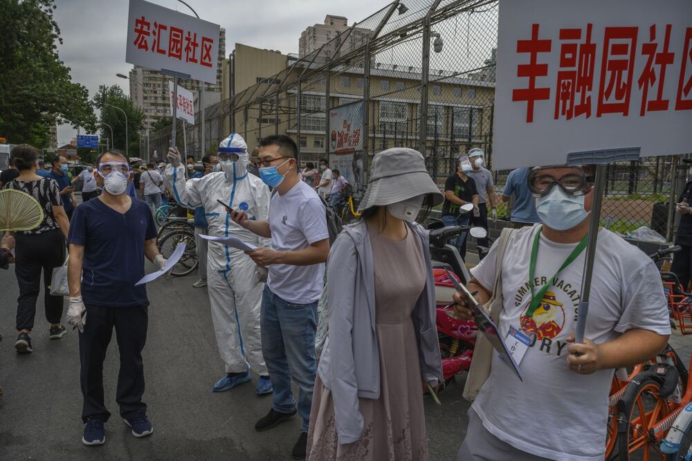 Epidemic control workers direct and register people at a testing site for people who have had contact with the the Xinfadi Wholesale Market or someone who has, in Beijing on June 15.