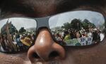 Marchers reflect in the sunglasses of Patrick, a member of the Latino advocacy group CASA de Maryland, during the 2017 climate march in Washington, D.C.