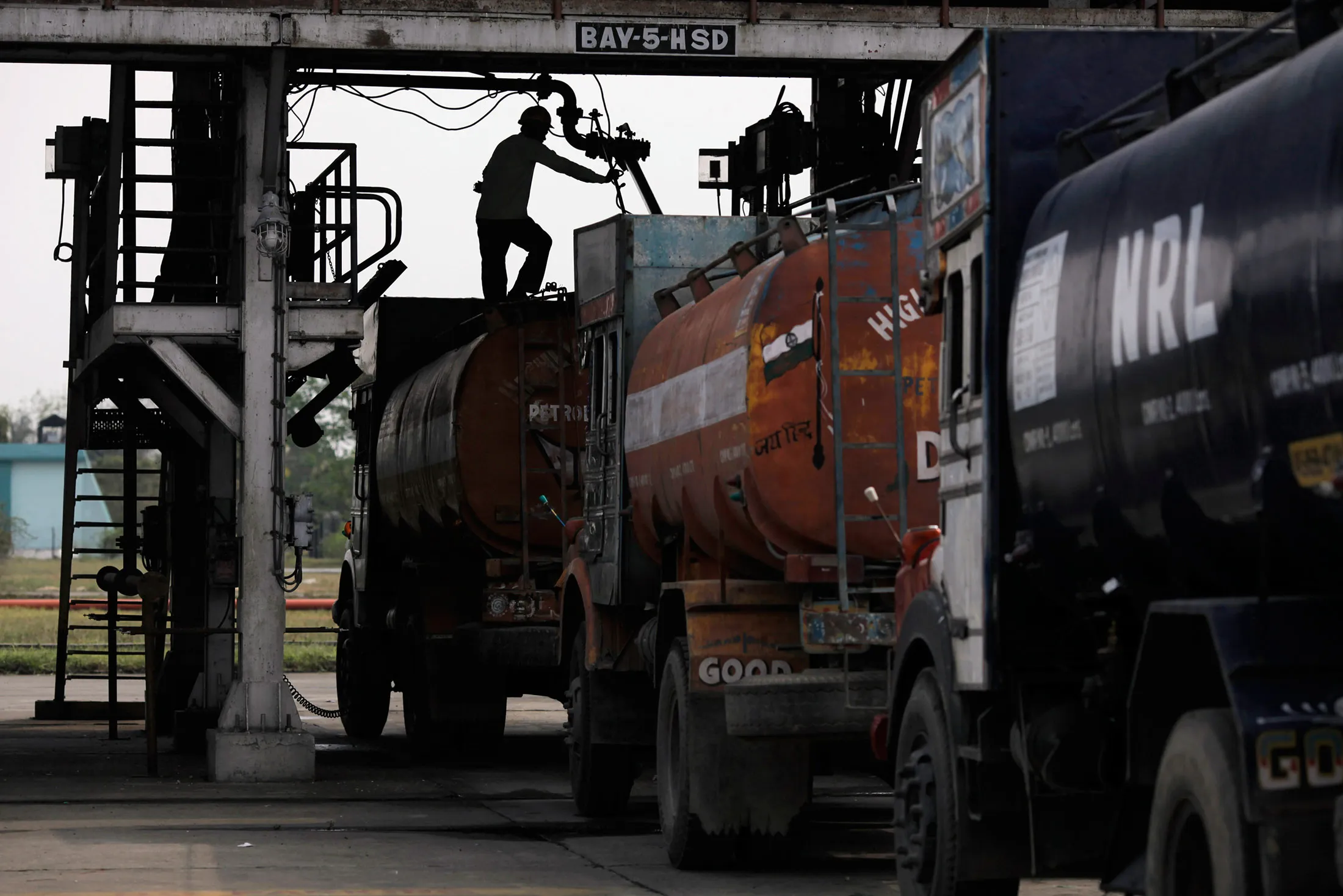 Trucks stand parked at the road loading gantry of the Numaligarh Refinery Ltd. complex in Golaghat, India.
