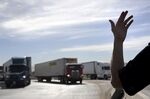 A U.S. Customs and Border Protection officer directs trucks entering the United States from Mexico in San Diego, California.