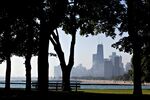 The city skyline stands in the background of trees in Lincoln Park in Chicago, Illinois.