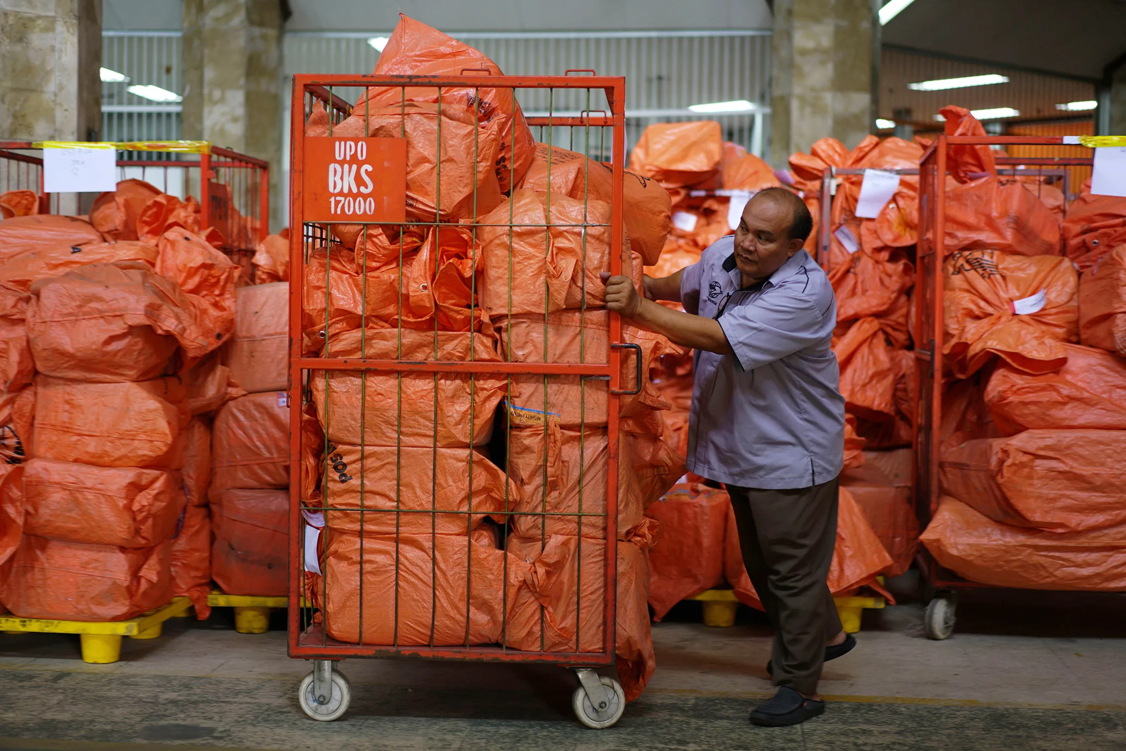 An employee pushes a trolley of letters and packages at a Pos&nbsp;Indonesia outlet&nbsp;in Jakarta.