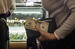 A shopper holds a $20 bill while waiting to pay at a Hospice Thrift Shoppe in Walnut Creek, California, U.S., on Tuesday, Nov. 9, 2021.